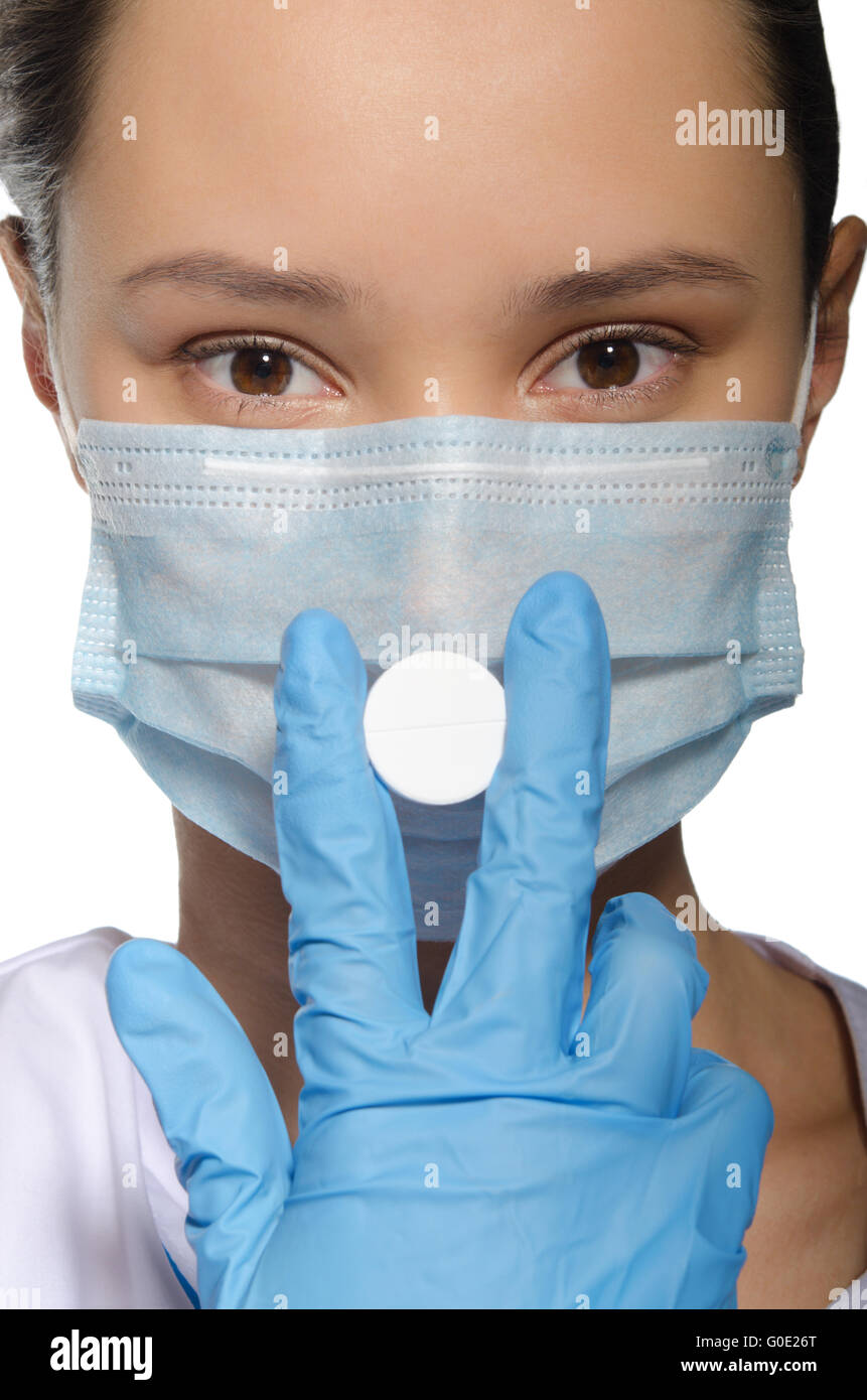 Doctor holding une pilule dans sa bouche masque fermé Banque D'Images