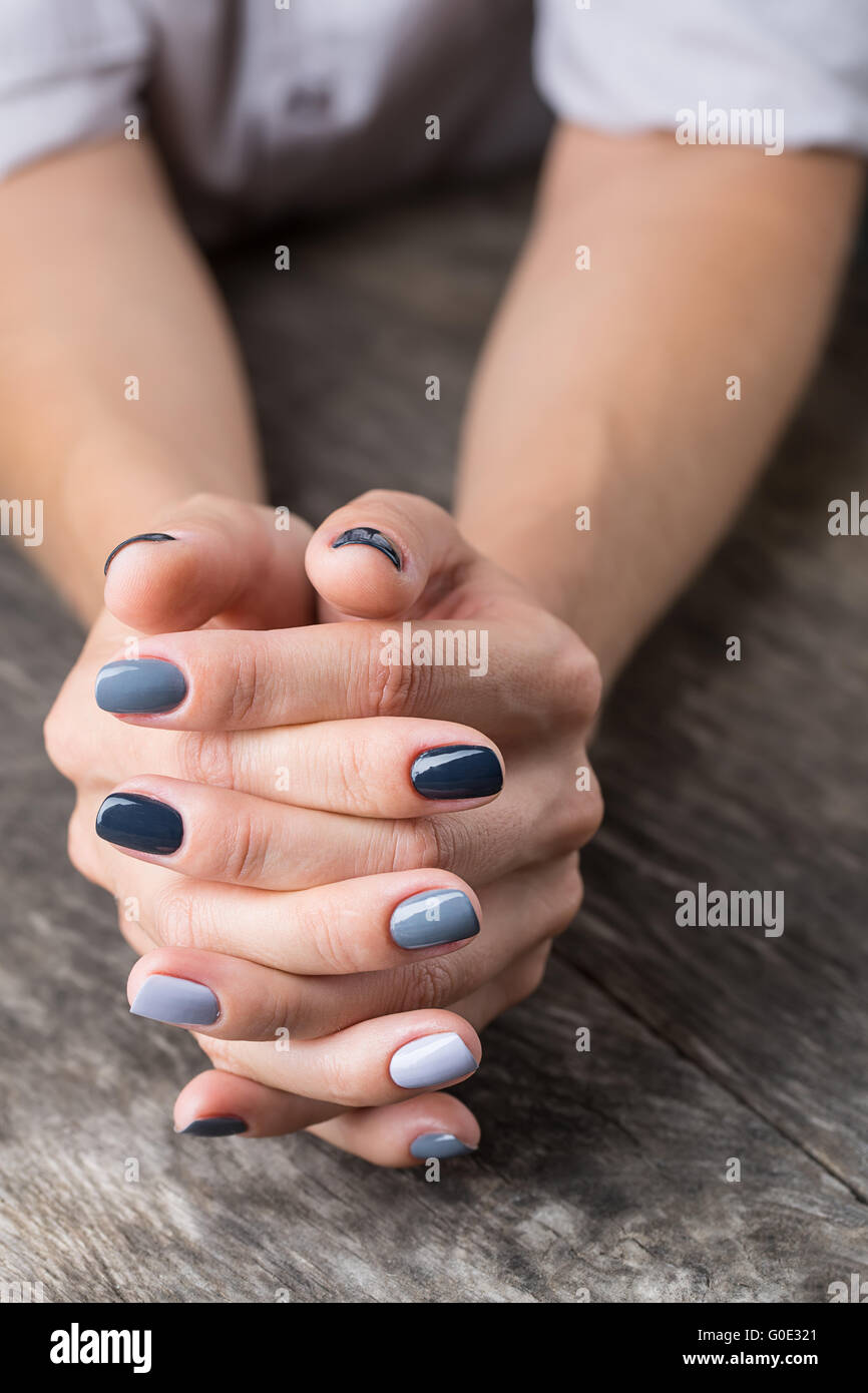 De belles mains avec la miniature peinte dans une couleur gris Banque D'Images
