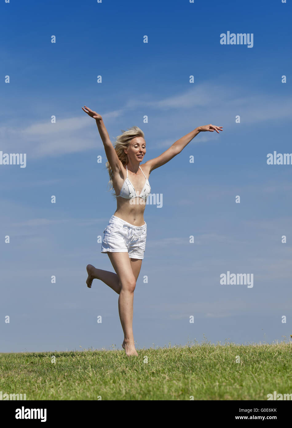 Happy woman in bikini blanc et shorts s'exécute dans un s Banque D'Images