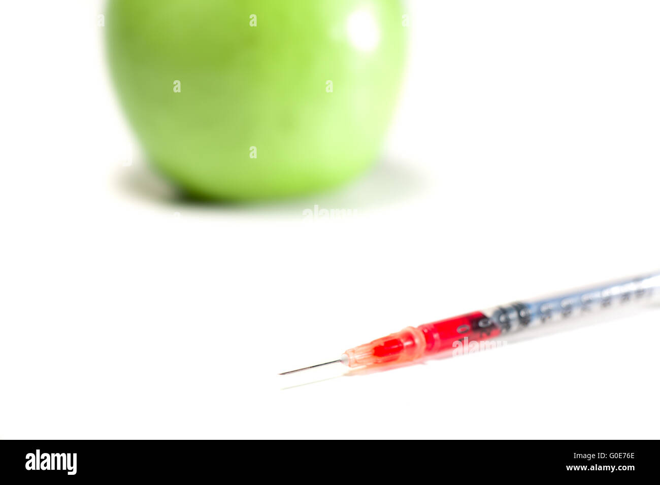 La pomme verte avec la seringue Banque D'Images