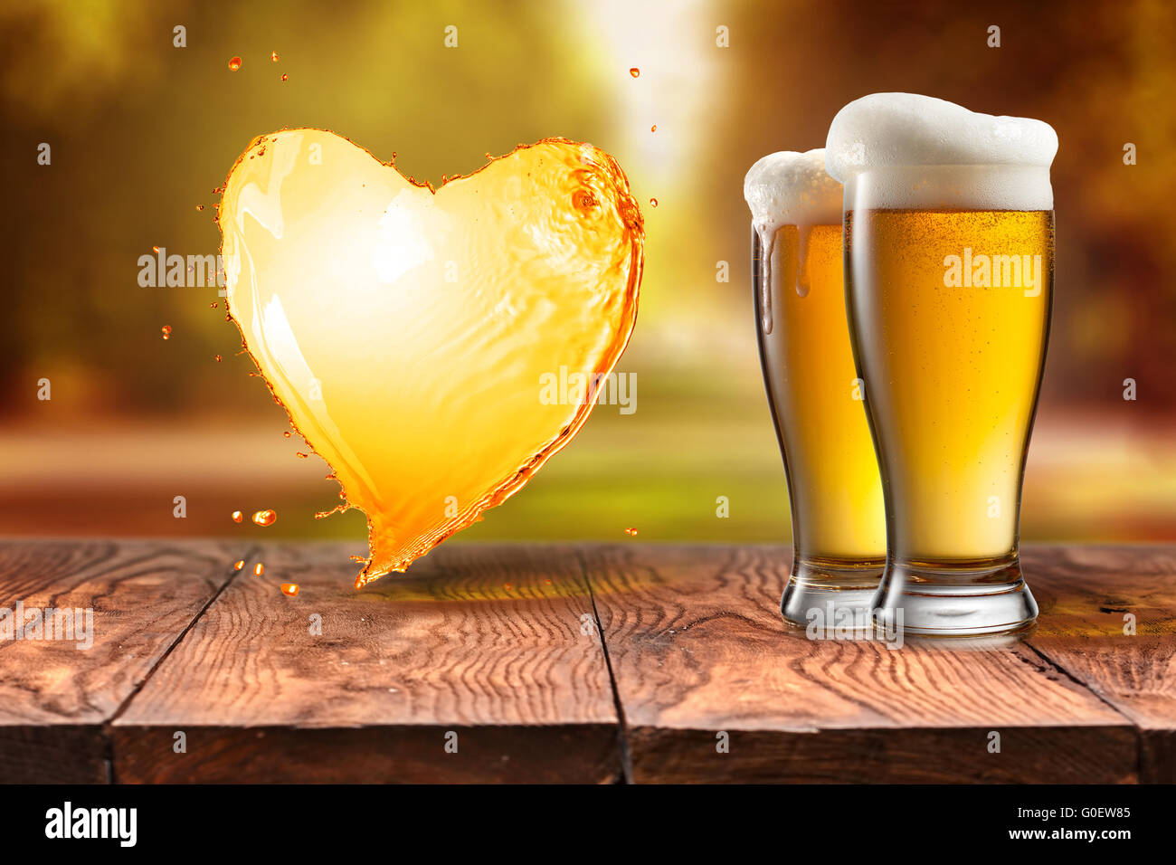 L'amour de la bière. La bière en verre avec coeur splash sur table en bois nouveau Banque D'Images
