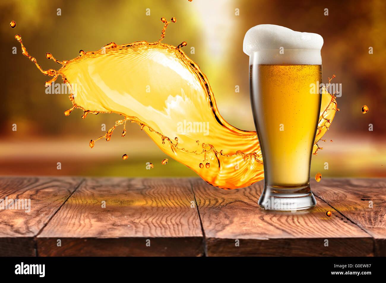 La bière en verre avec des vagues sur la table en bois contre les feuilles d'automne Banque D'Images
