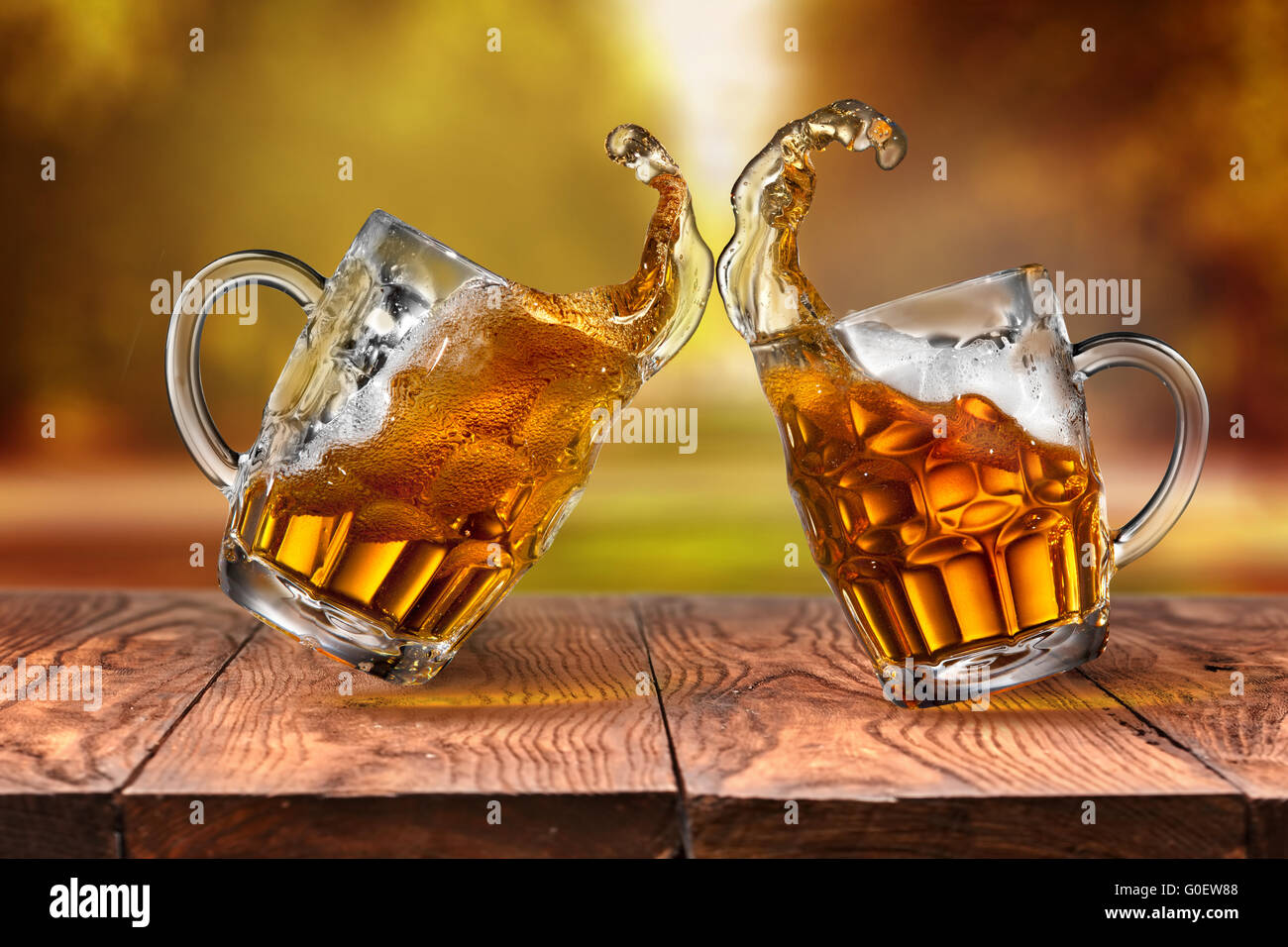 La bière dans des verres avec des vagues sur la table en bois contre les feuilles d'automne Banque D'Images