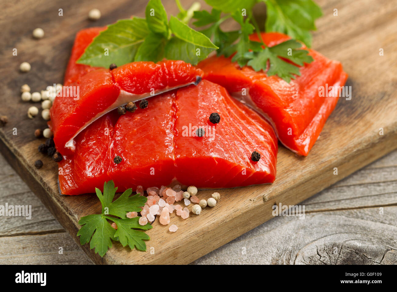 Rouge vif frais filets de saumon de la rivière Copper sur serveur en bois rustique avec des épices et herbes Banque D'Images