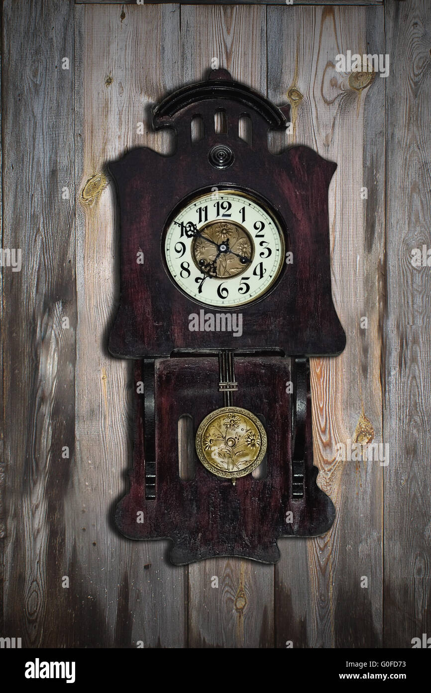 Vieille horloge à pendule sur l'arrière-plan de mur en bois Banque D'Images