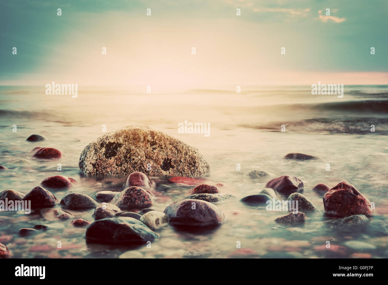 Coucher de soleil spectaculaire sur une plage de rochers. Mer Baltique. Thème Paysage marin Banque D'Images