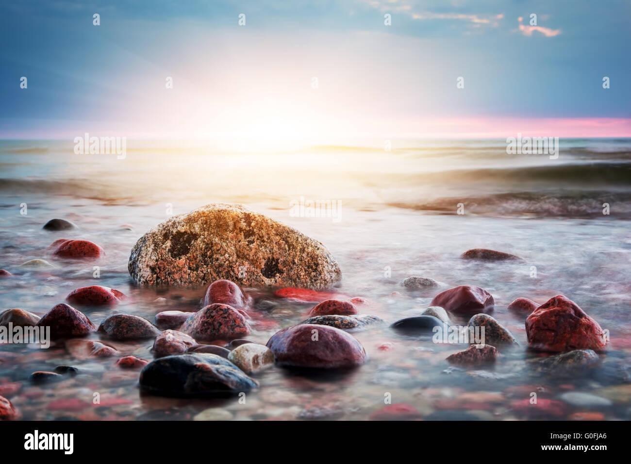 Coucher de soleil coloré spectaculaire sur une plage de rochers. Mer Baltique. Thème Paysage marin Banque D'Images