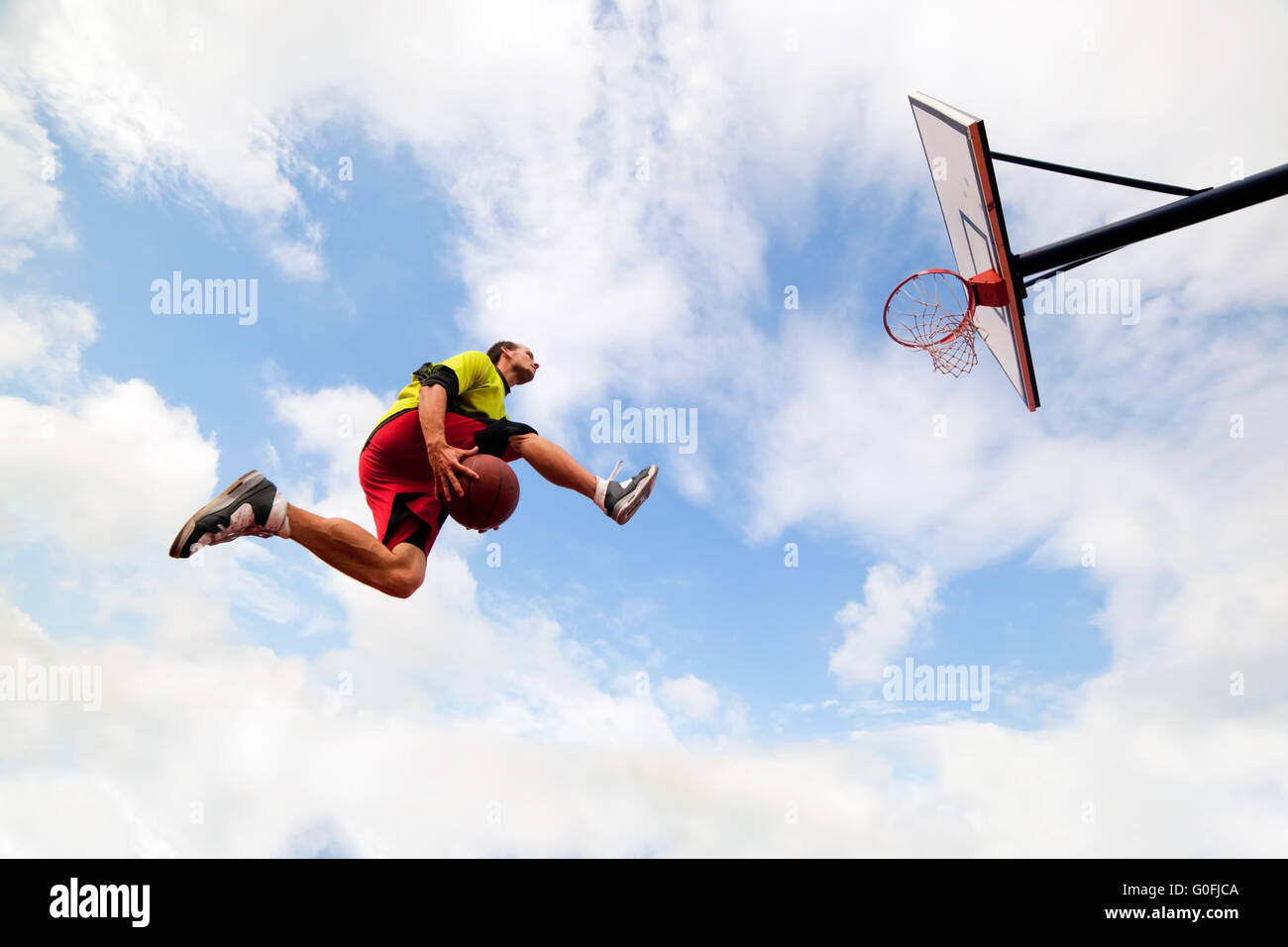 Jeune homme de saut et de faire un fantastique jeu slam dunk streetball Banque D'Images