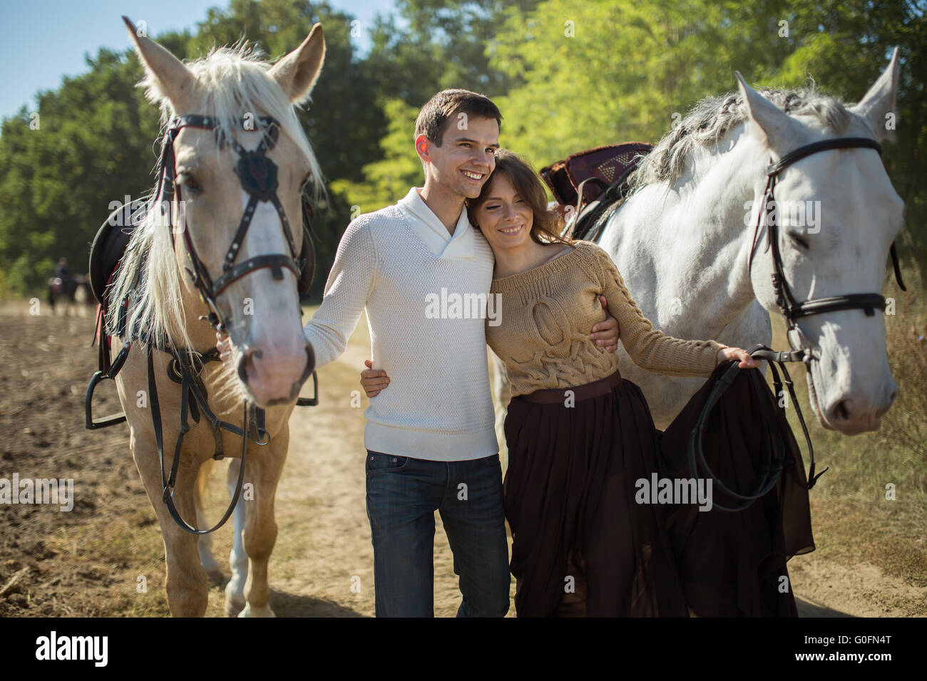 Jeune couple en train de marcher dans un endroit pittoresque avec les chevaux Banque D'Images