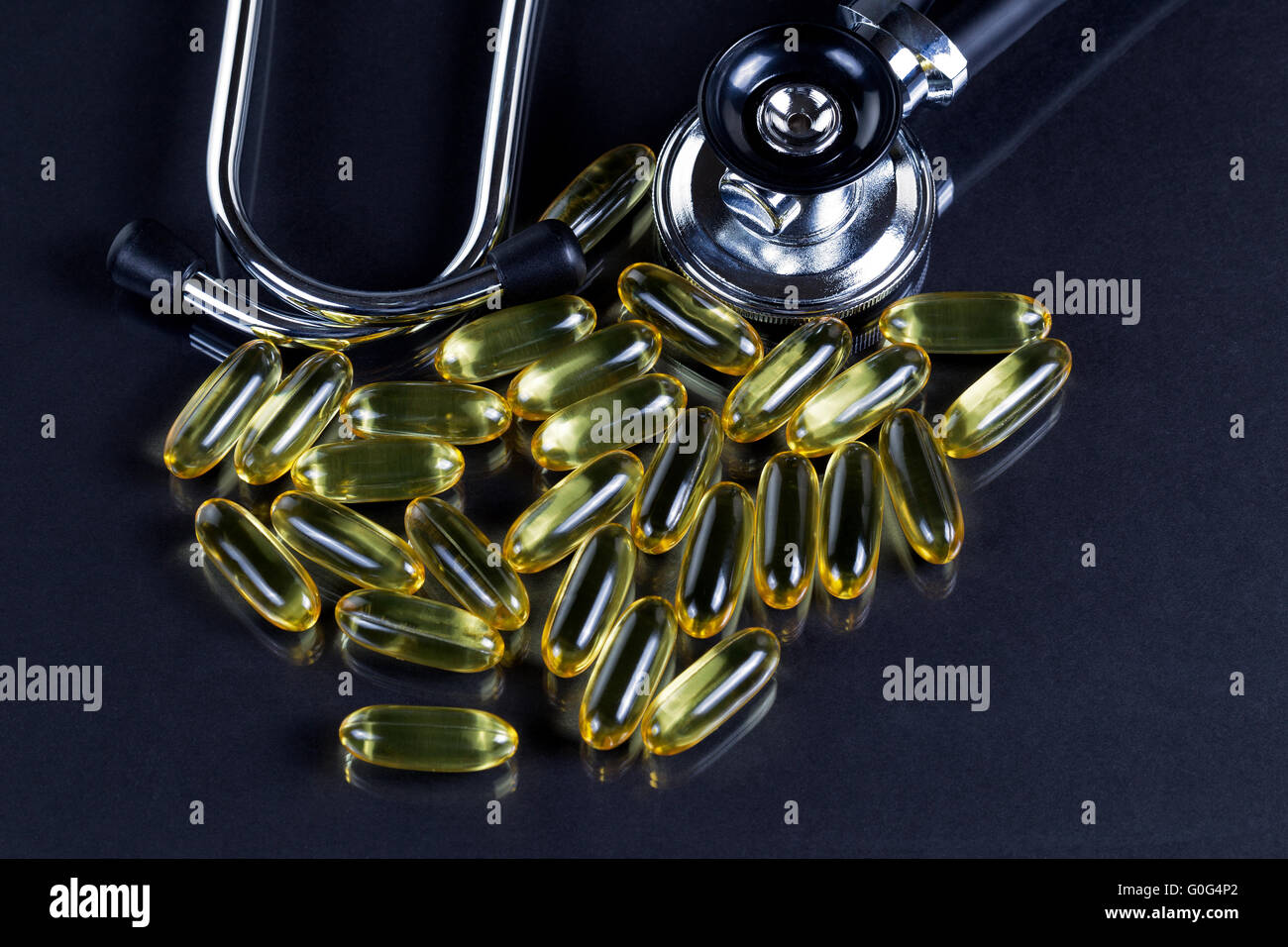 Des capsules d'huile de poisson en bonne santé pour une bonne santé sur fond noir Banque D'Images