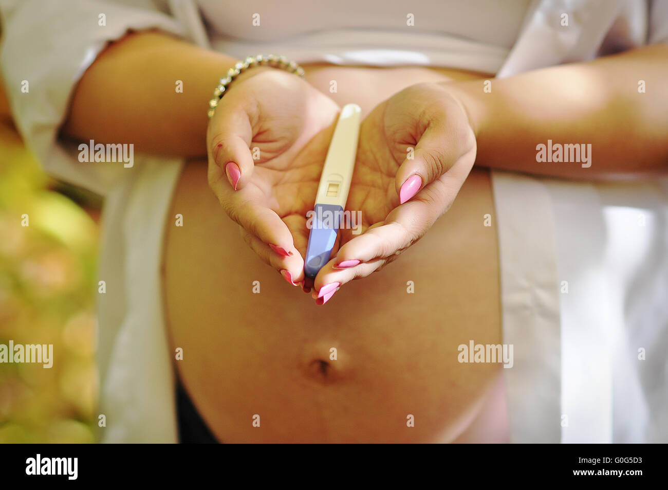 Pregnant woman holding sur le test de grossesse à la main Banque D'Images
