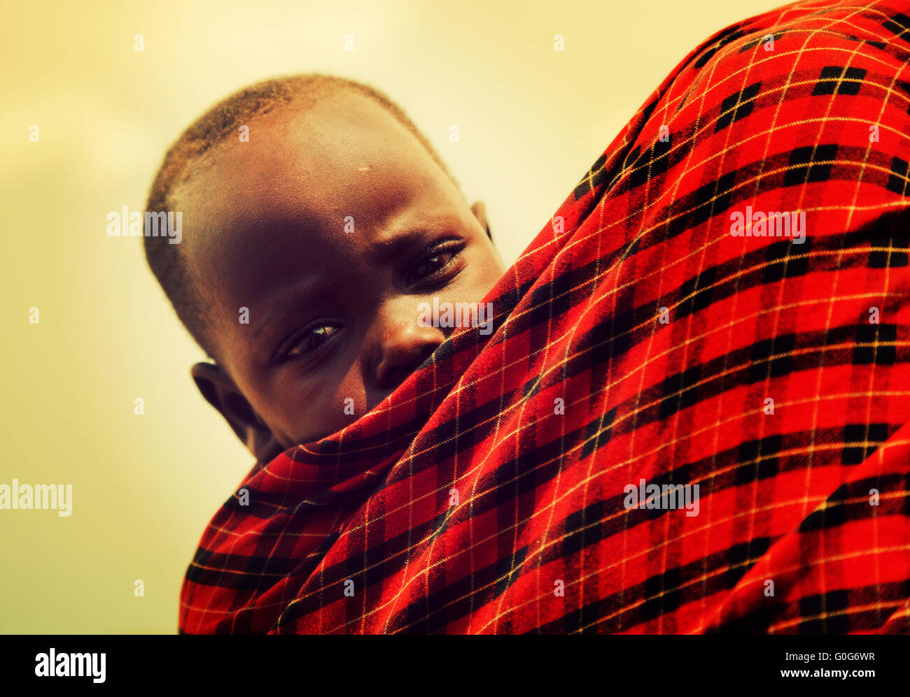 Bébé Maasai menées par sa mère en Tanzanie, Afrique Banque D'Images