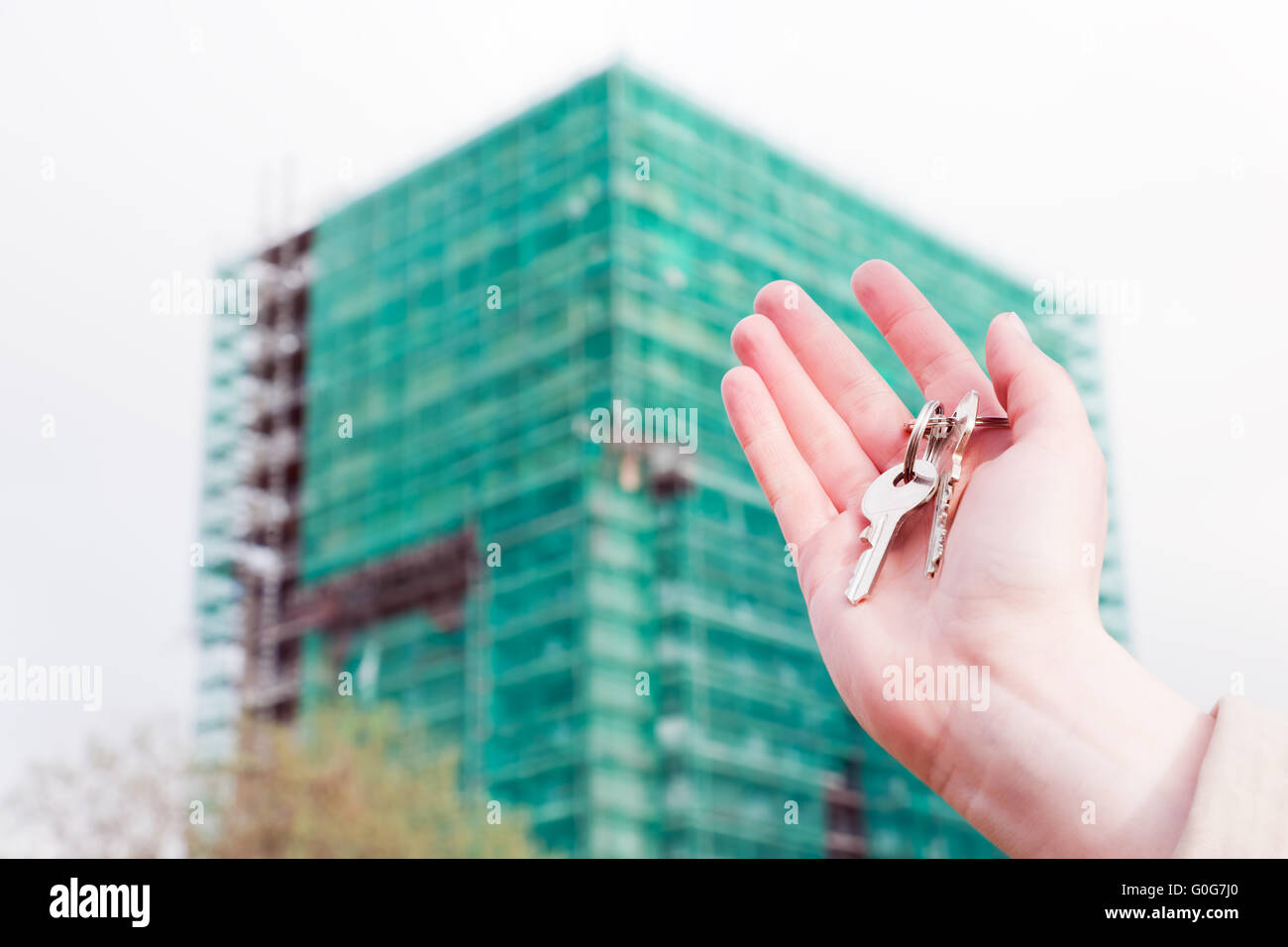 Un agent immobilier holding clés d'un nouvel appartement dans ses mains. Bâtiment en construction immobilier Banque D'Images