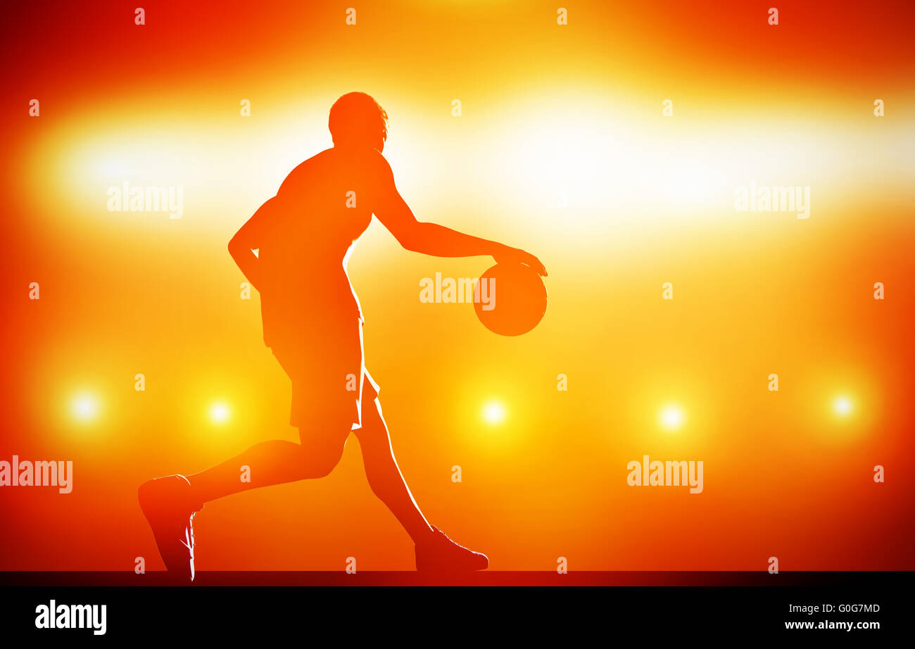 Basket-ball dribble silhouette avec balle sur fond rouge avec des feux d'action Banque D'Images