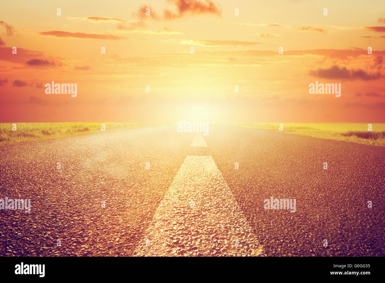 Vide longue route asphaltée vers coucher de soleil. L'échelle Banque D'Images