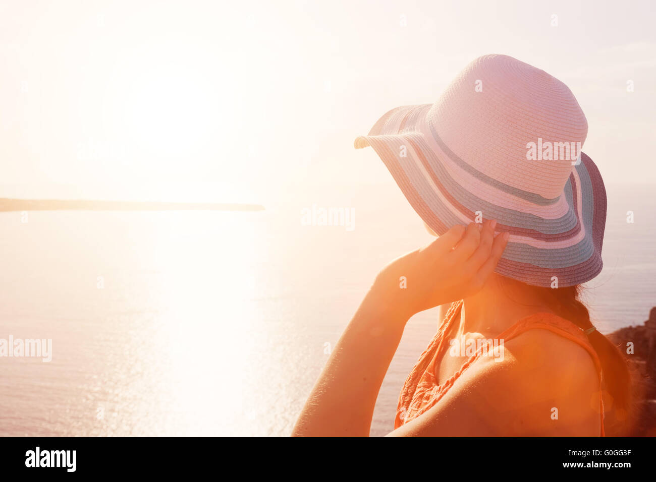 Happy woman in sun hat admirant la vue sur la mer à Santorin Banque D'Images
