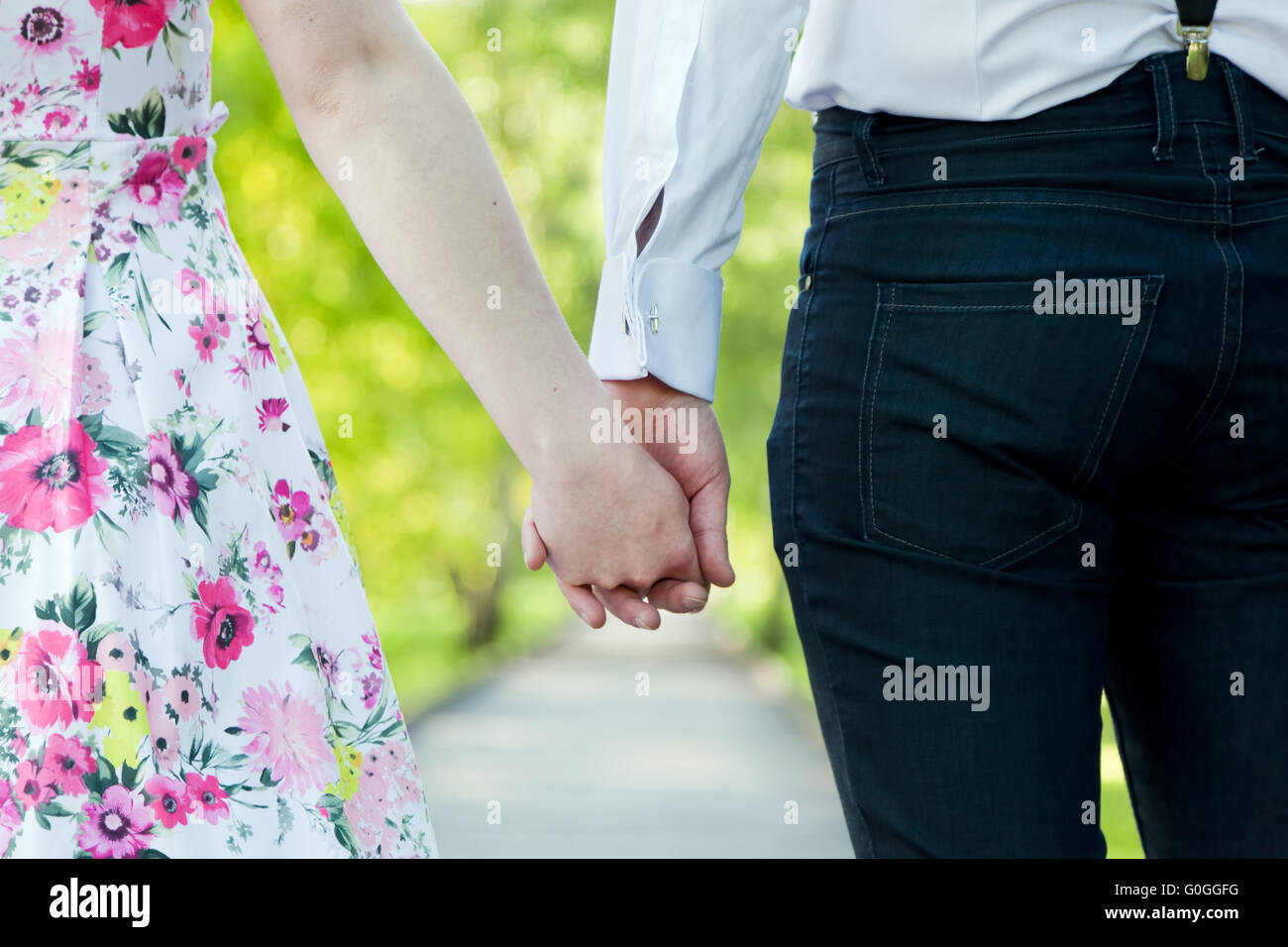 Jeune couple amoureux se tenant la main en parc d'été. Dating Banque D'Images