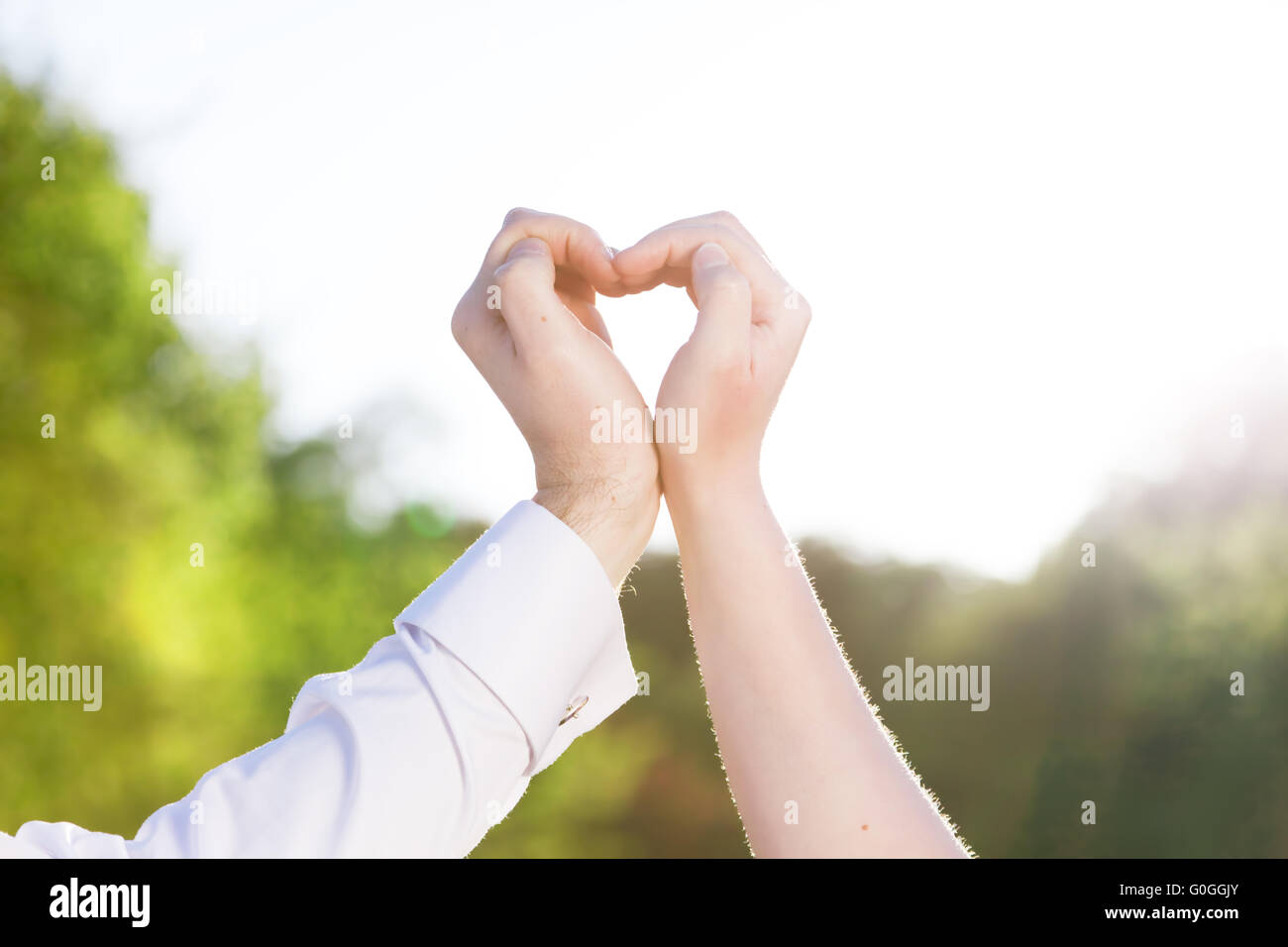 Couple dans la fabrication d'amour un cœur avec leurs mains à l'extérieur. Banque D'Images
