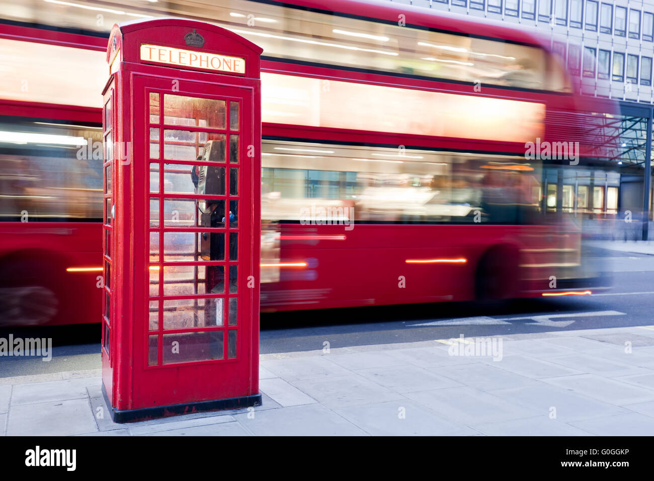 Londres, Royaume-Uni. Cabine téléphonique rouge et bus rouge passant. Symboles de l'Angleterre. Banque D'Images