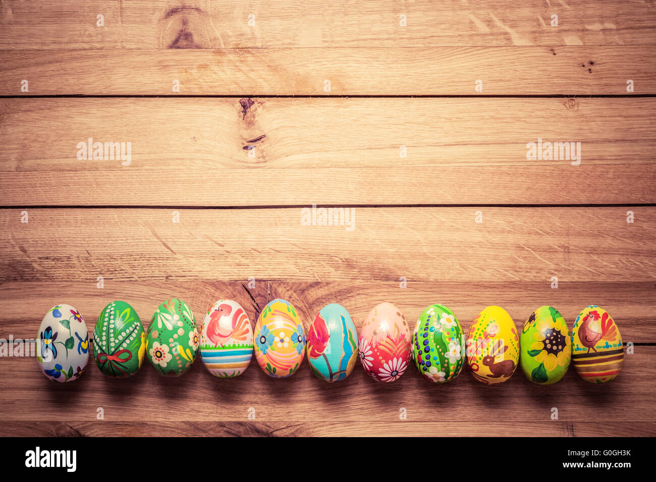 Peints à la main les oeufs de Pâques colorés sur le bois. Fait main unique, vintage. Banque D'Images
