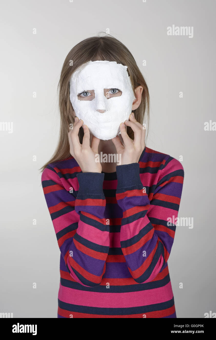 Petite fille blonde avec masque en plâtre Banque D'Images