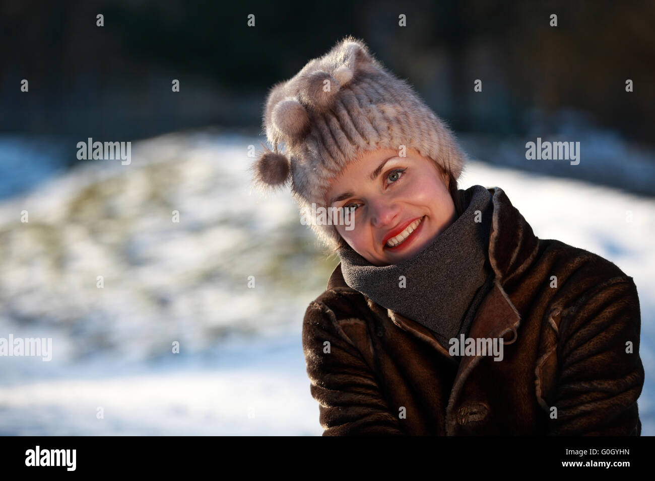 Belle fille avec bobble hat et veste de daim dans la neige Banque D'Images