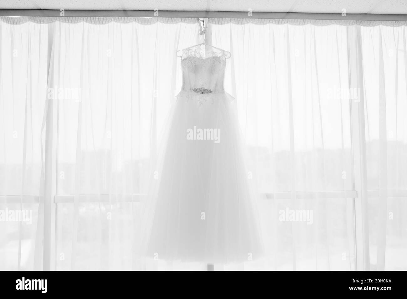 Belle robe de mariage blanc accroché par fenêtre Banque D'Images