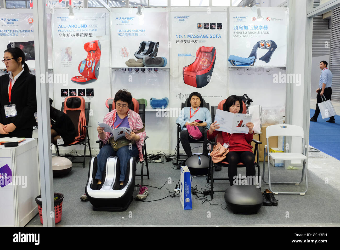 Les gens à Shenzhen, Chine, en essayant de fauteuils de massage. Banque D'Images