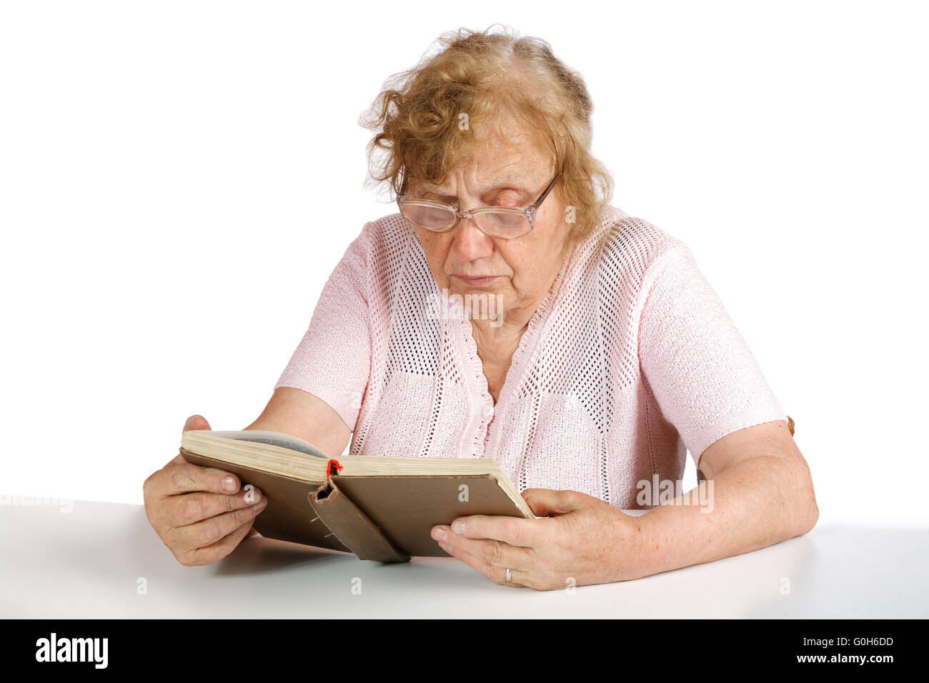 Lunettes de vieille femme au lit le livre sur un fond blanc Banque D'Images