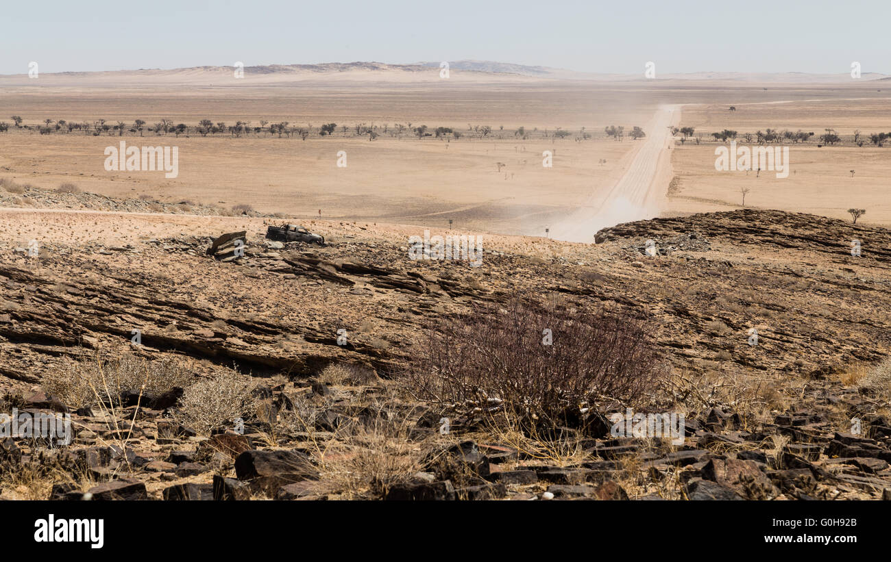 Route solitaire dans le désert de Namibie. Travelng dans l'inconnu. L'Afrique. Voiture brûlée le long road. Banque D'Images