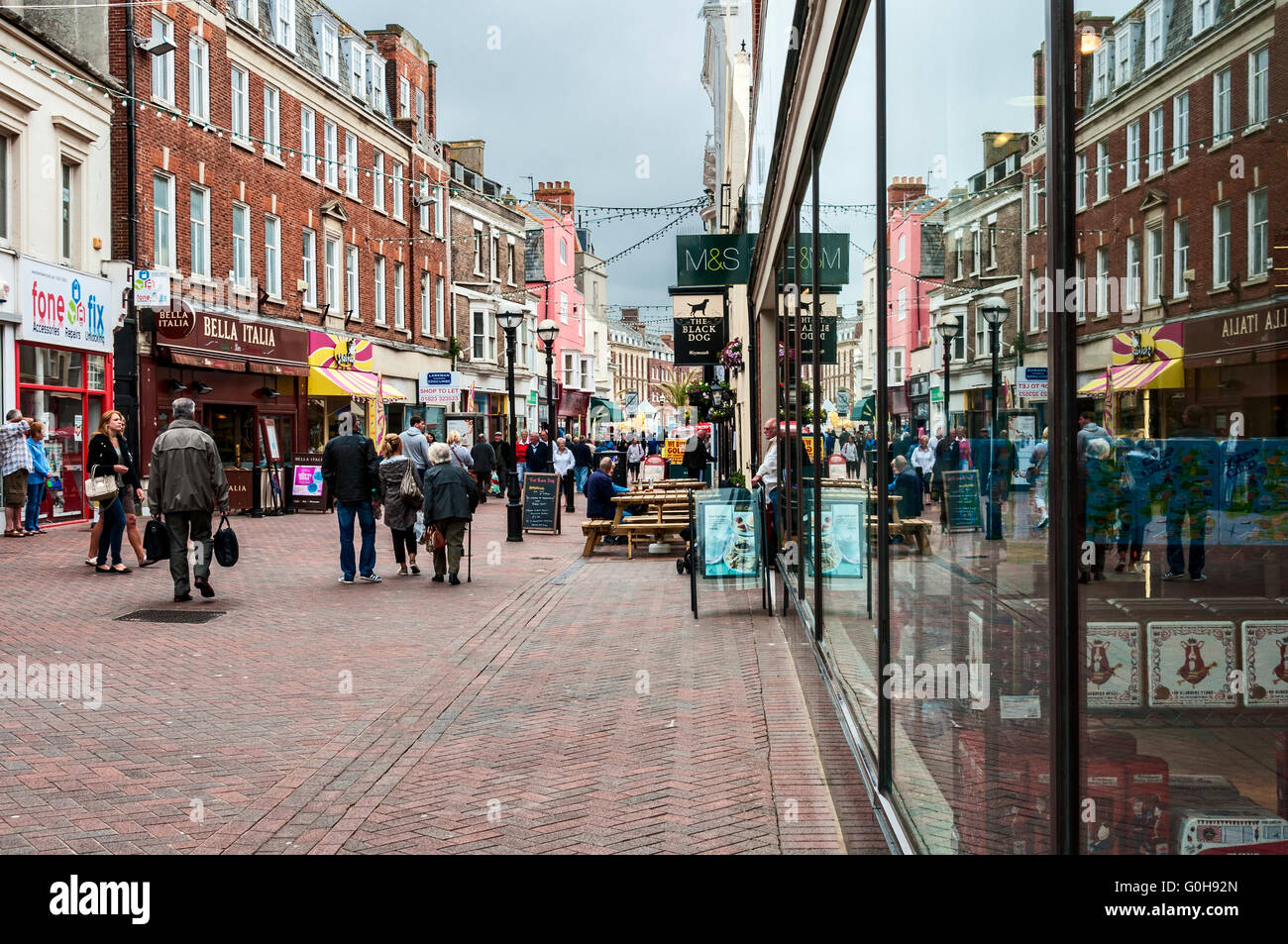 Réflexions d'acheteurs peut être vu dans les grandes baies vitrées d'un magasin situé dans un centre commercial de Weymouth Banque D'Images