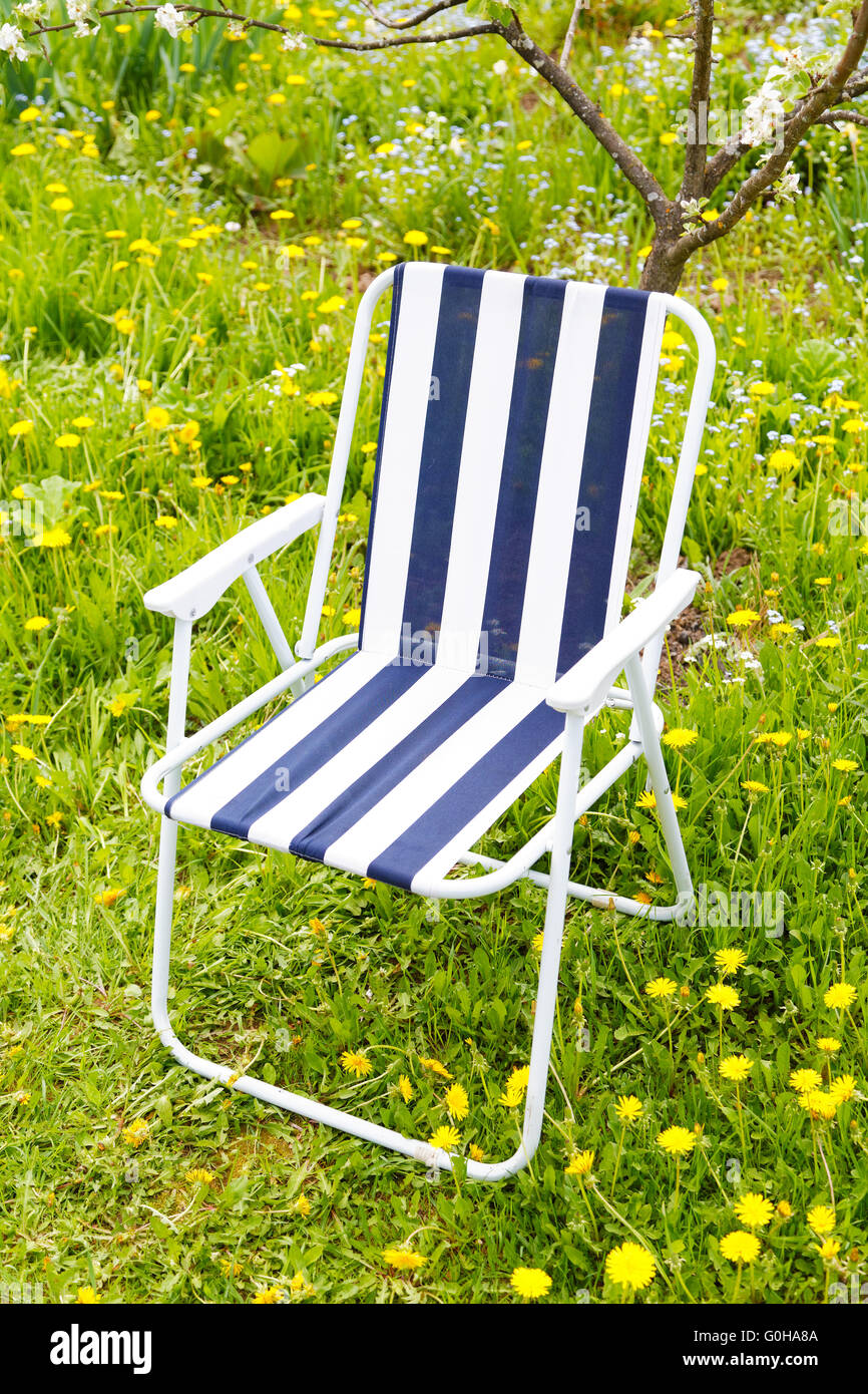 Chaise pliante sous un pommier en fleurs Banque D'Images