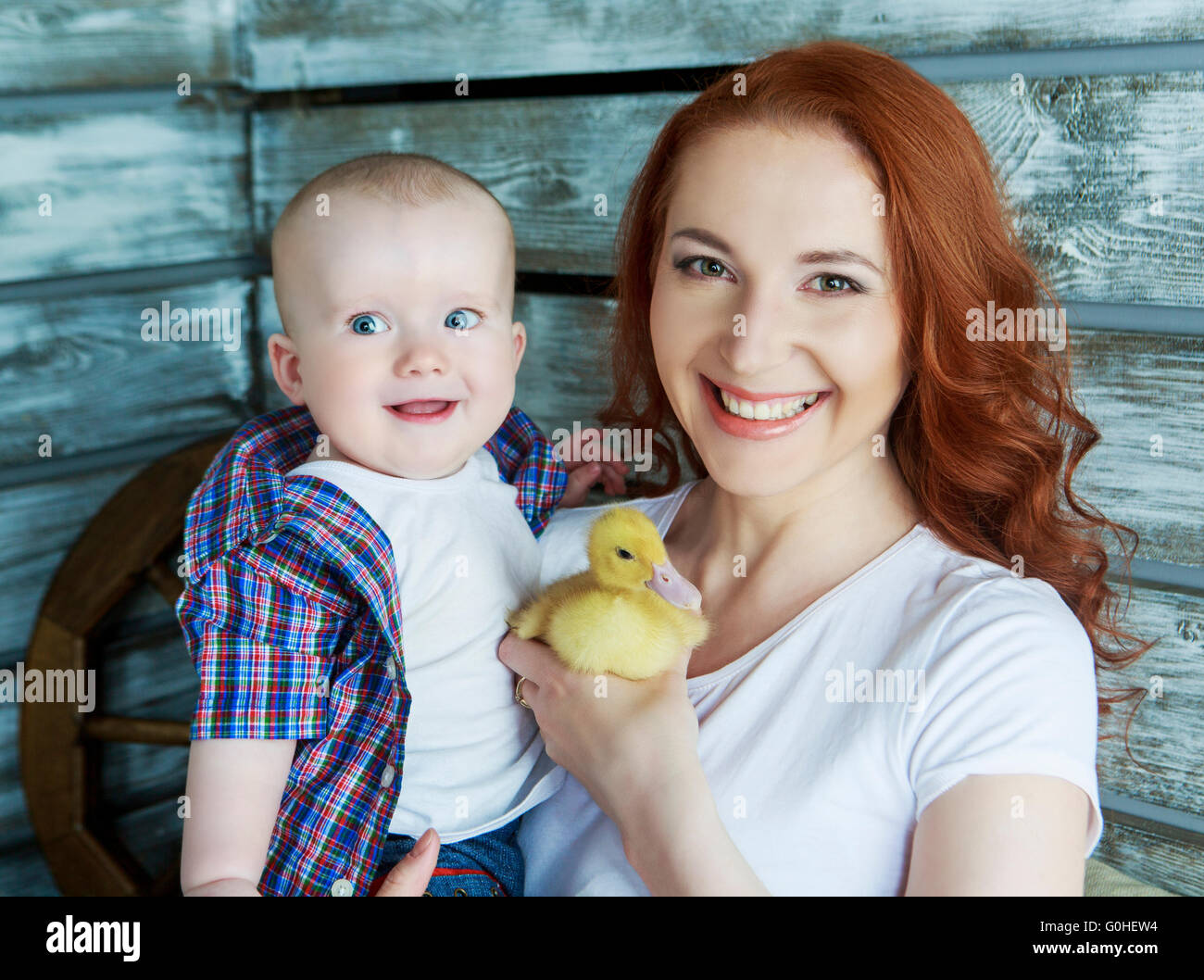 Belle jeune mère et son bébé jouant avec un caneton Banque D'Images