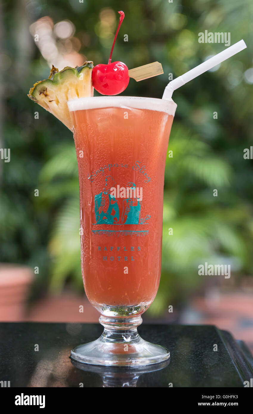 Singapore Sling Cocktail servi dans un verre d'ouragan avec cerise au marasquin tranche d'ananas, le Raffles Hotel, Singapore Banque D'Images