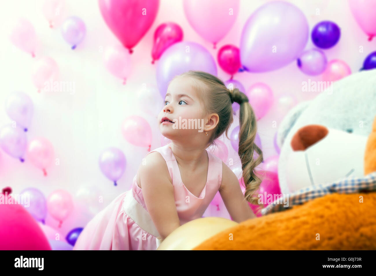 Jolie petite dame posant sur fond de ballons Banque D'Images