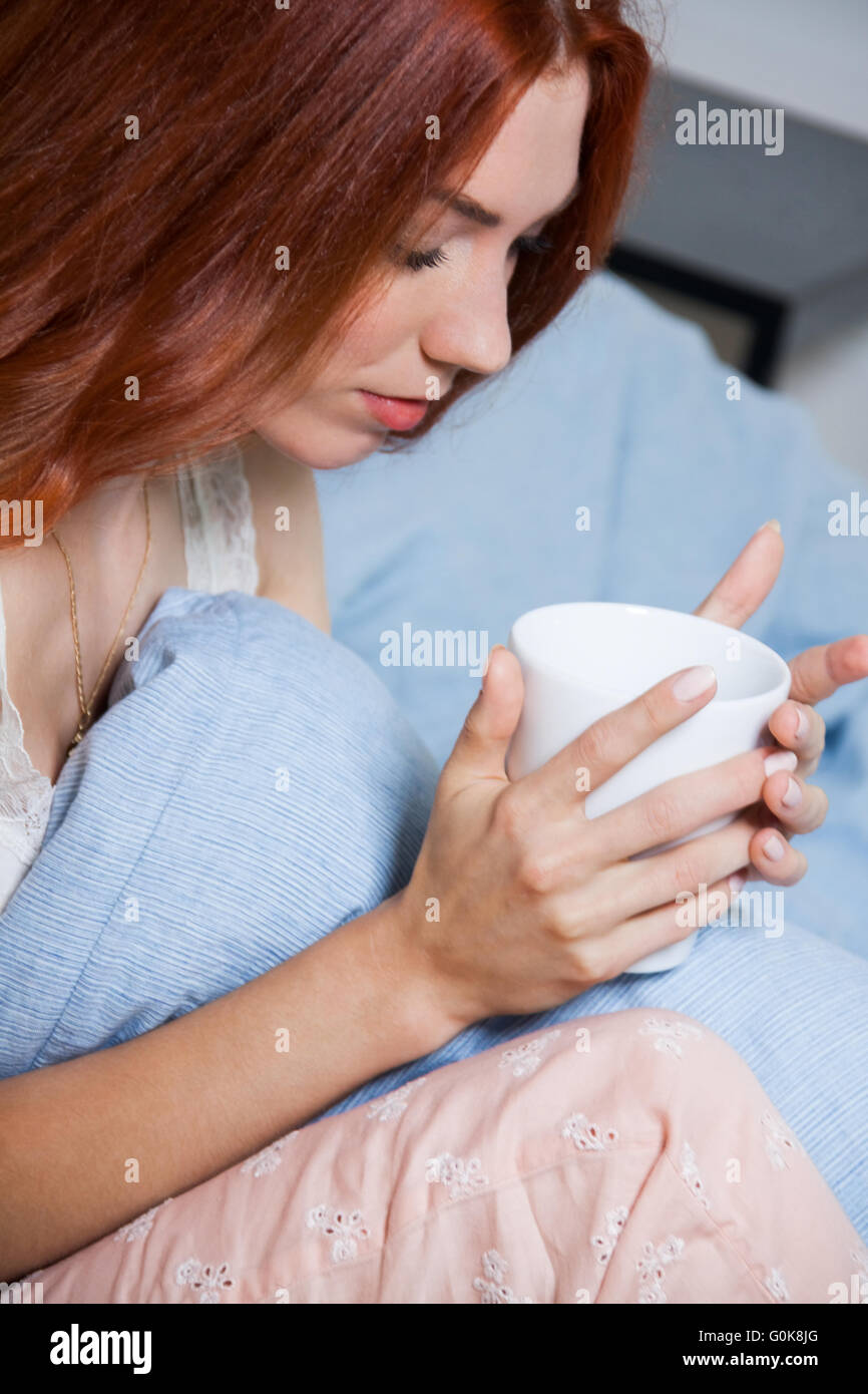 Pensive Woman Having un café dans son lit Banque D'Images