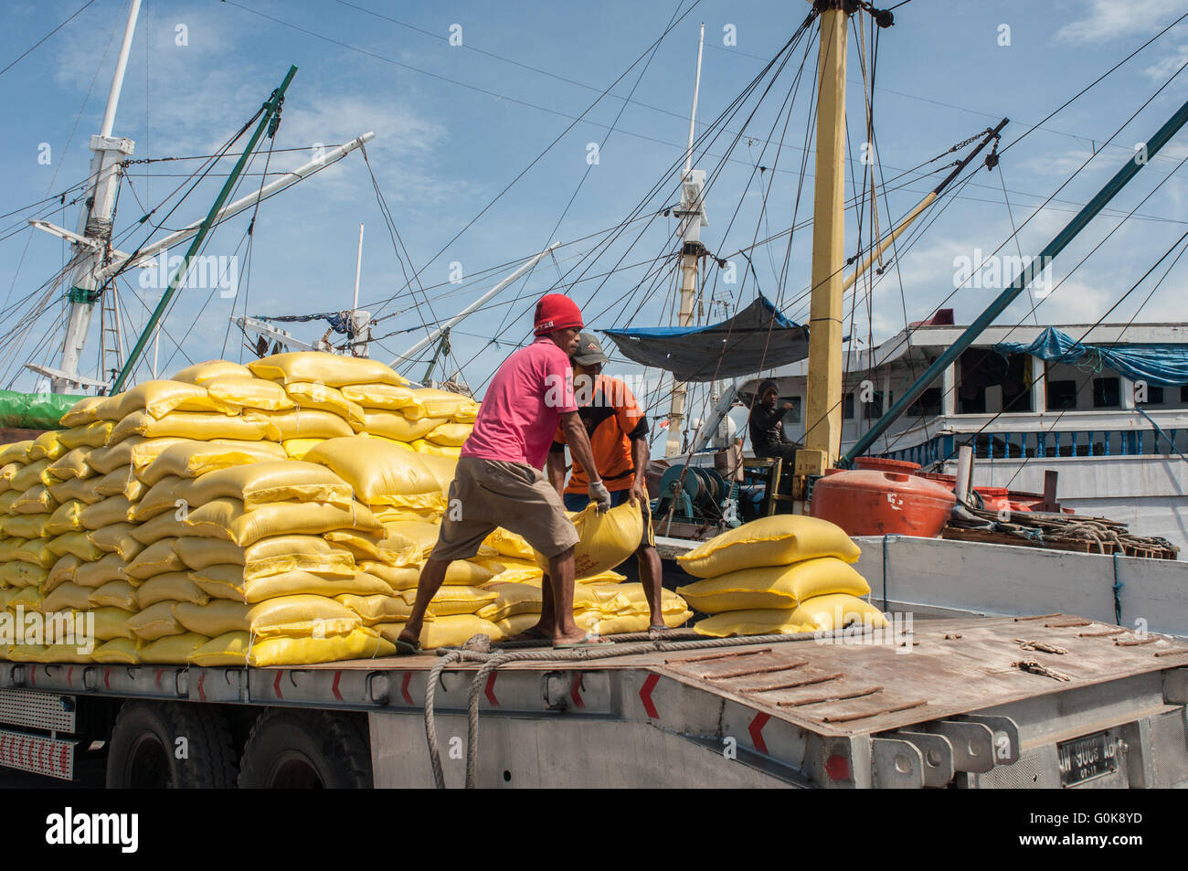 Les travailleurs chargés des sacs de ciment dans la coque d'un bateau au port de Paotere à Makassar, Indonésie. Banque D'Images