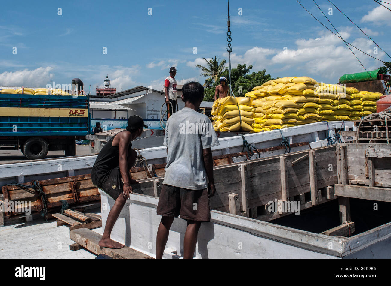 Les travailleurs chargés des sacs de ciment dans la coque d'un bateau au port de Paotere à Makassar, Indonésie. Banque D'Images