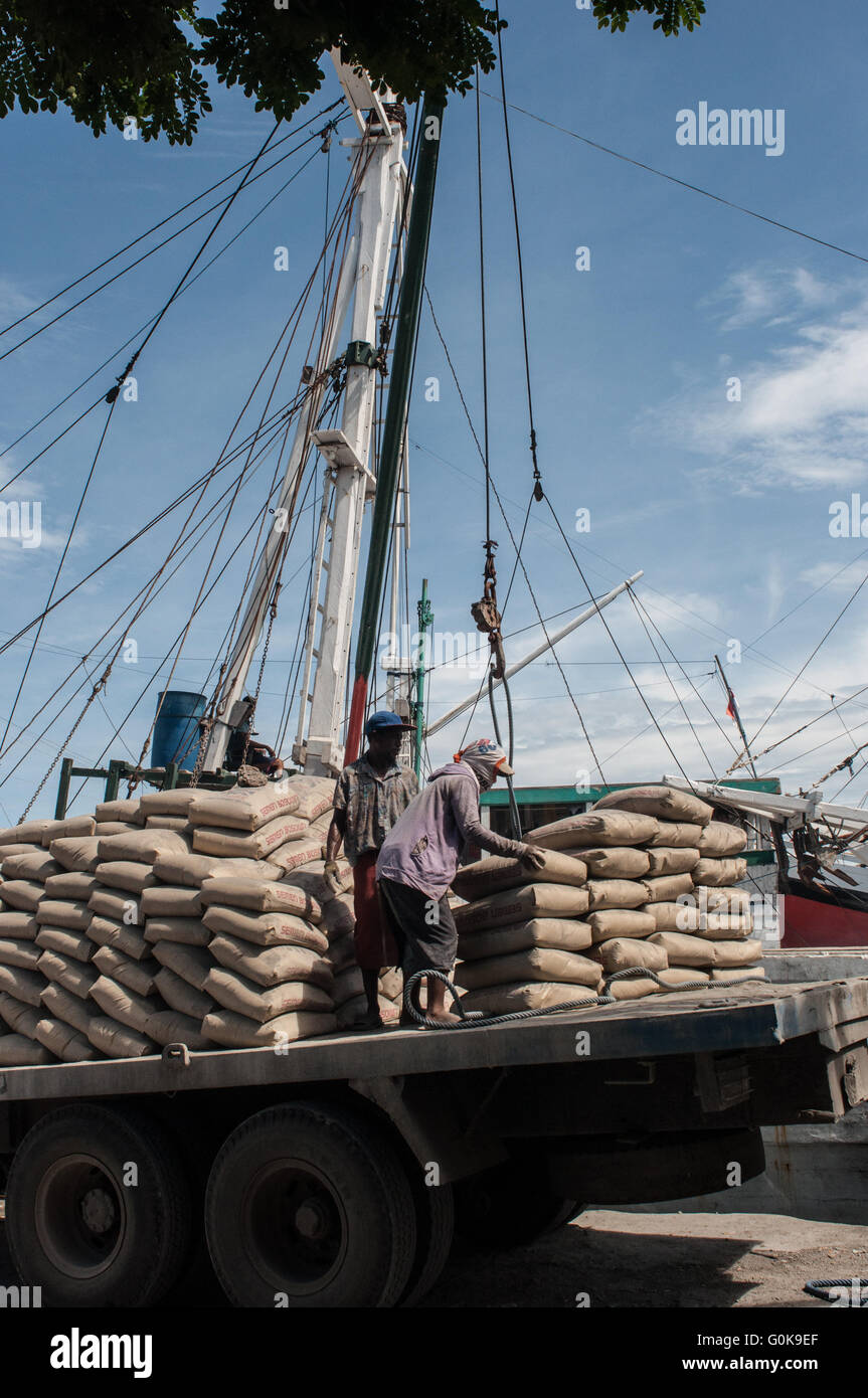 Les travailleurs chargés des sacs de ciment à la coque d'un bateau au port de Paotere à Makassar, Indonésie. Banque D'Images