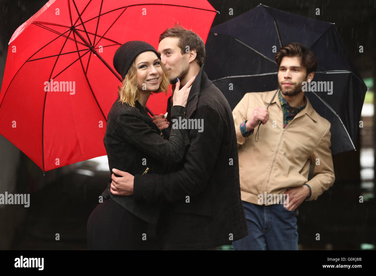 L'amour des jeunes sous les parapluie rouge Banque D'Images