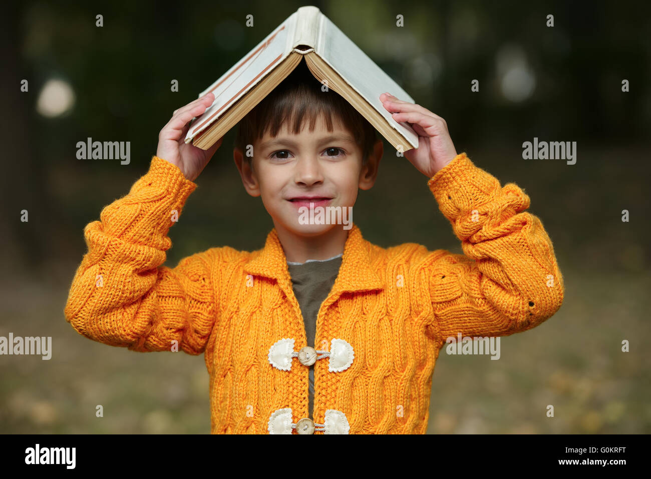 Funny boy avec livre sur sa tête Banque D'Images