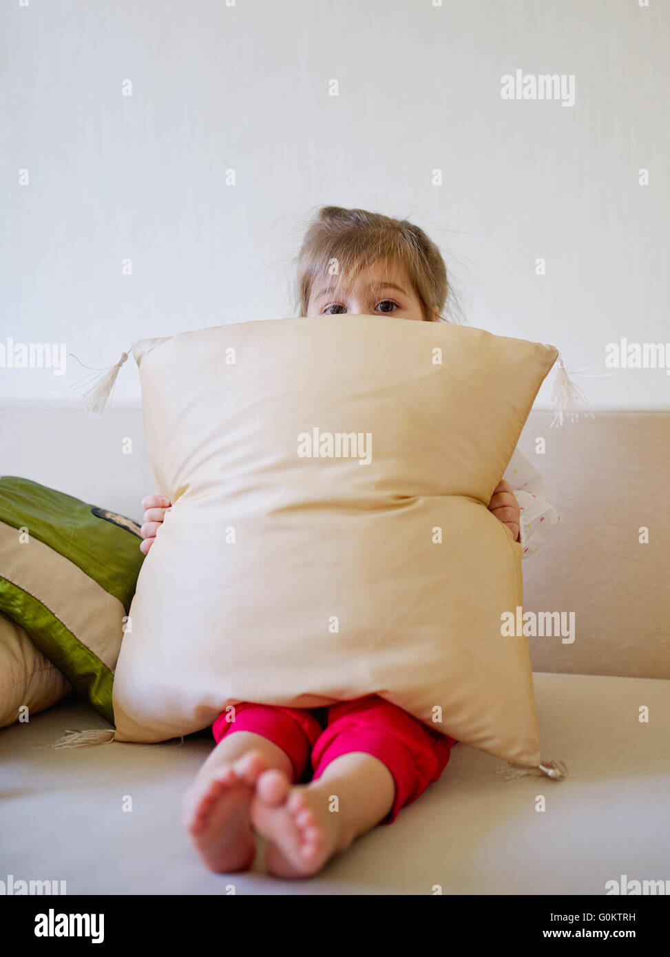 Fille de se cacher derrière un oreiller Photo Stock - Alamy