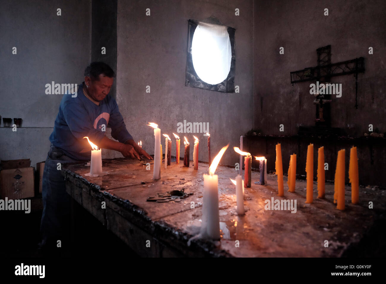 Homme de la région de cire de nettoyage des bougies au cimetière de Chichicastenango également connu sous le nom de Santo Tomás Chichicastenango une ville dans le département de Guatemala El Quiché, connu pour sa culture Maya Kiche traditionnels. Banque D'Images