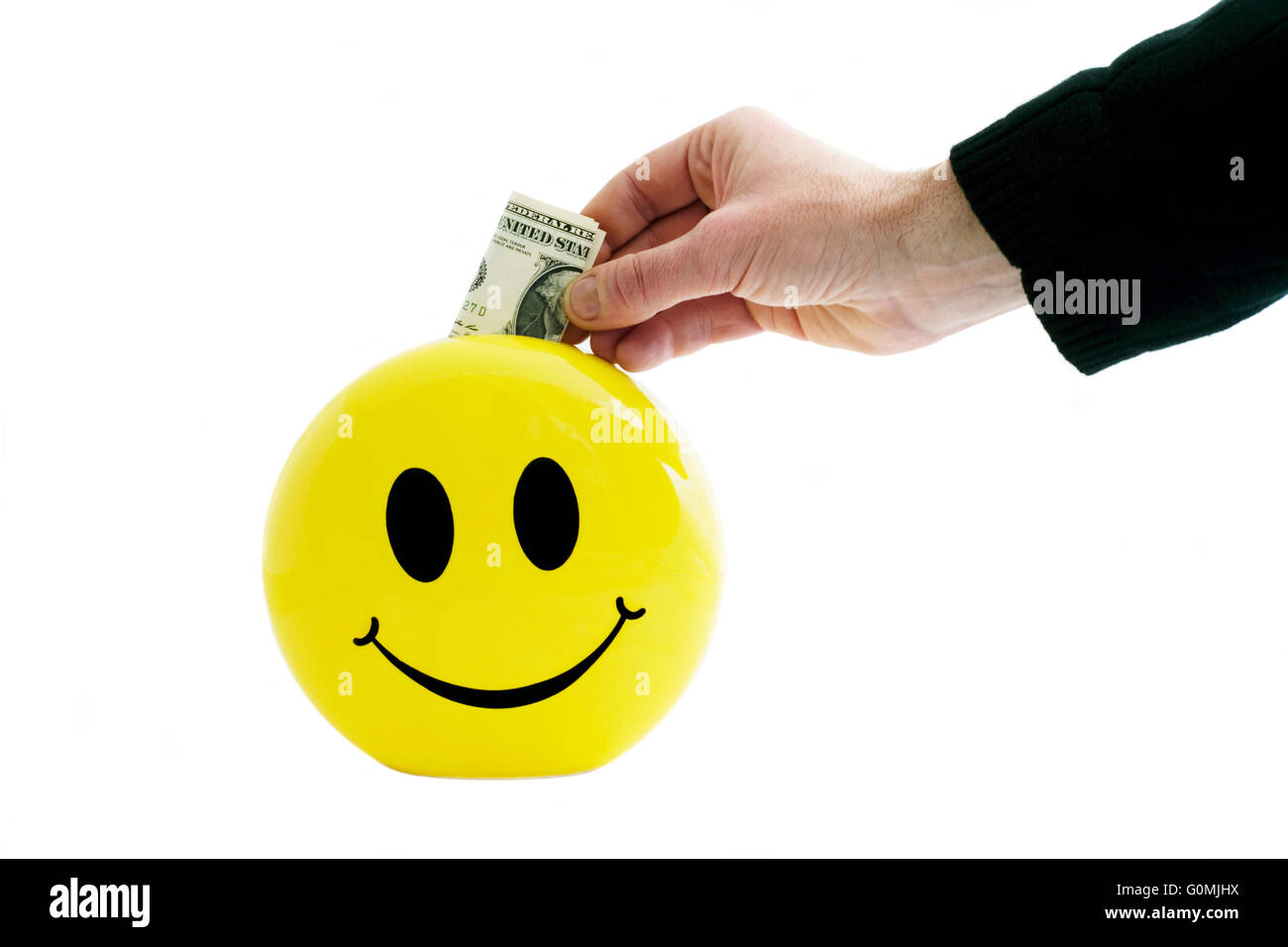 L'homme mettant l'argent dans une boîte d'épargne smiley Banque D'Images