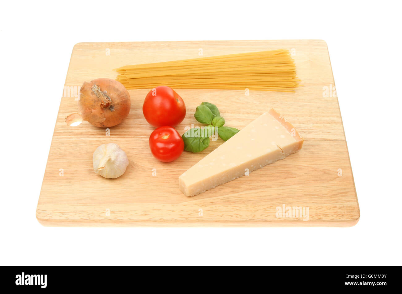 Ingrédients pour une recette de spaghetti sur une planche à découper en bois blanc isolé contre Banque D'Images