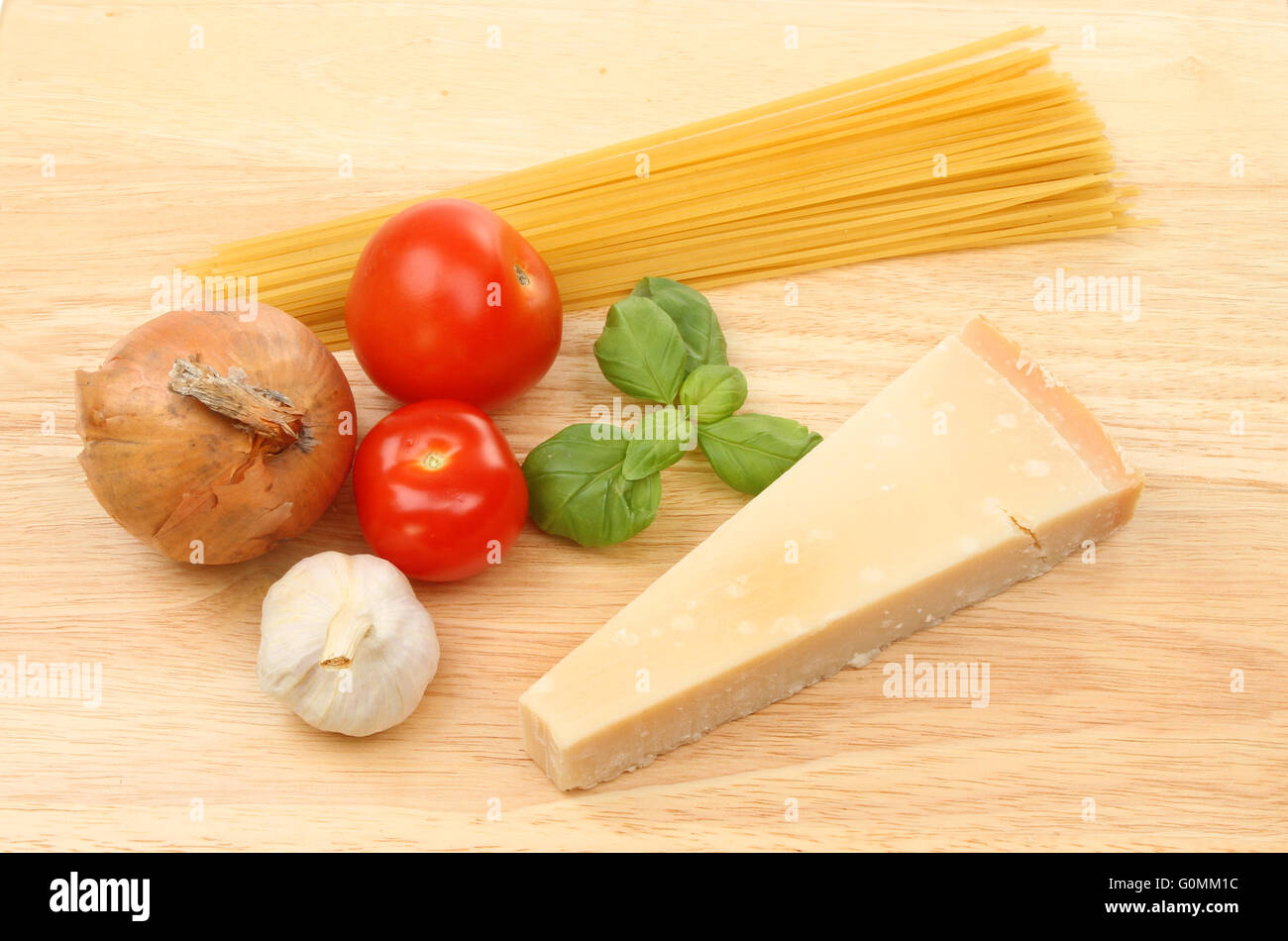 Ingrédients pour une recette de spaghetti sur une planche à découper en bois Banque D'Images