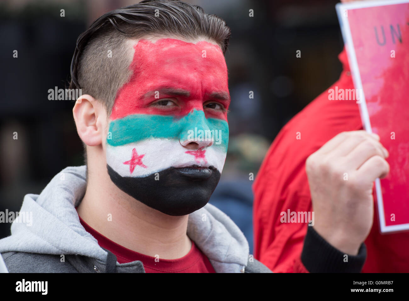 Un réfugié avec drapeau syrien face paint manifestations lors du défilé du Premier mai à Oslo, Norvège, le 1 mai 2016. Banque D'Images