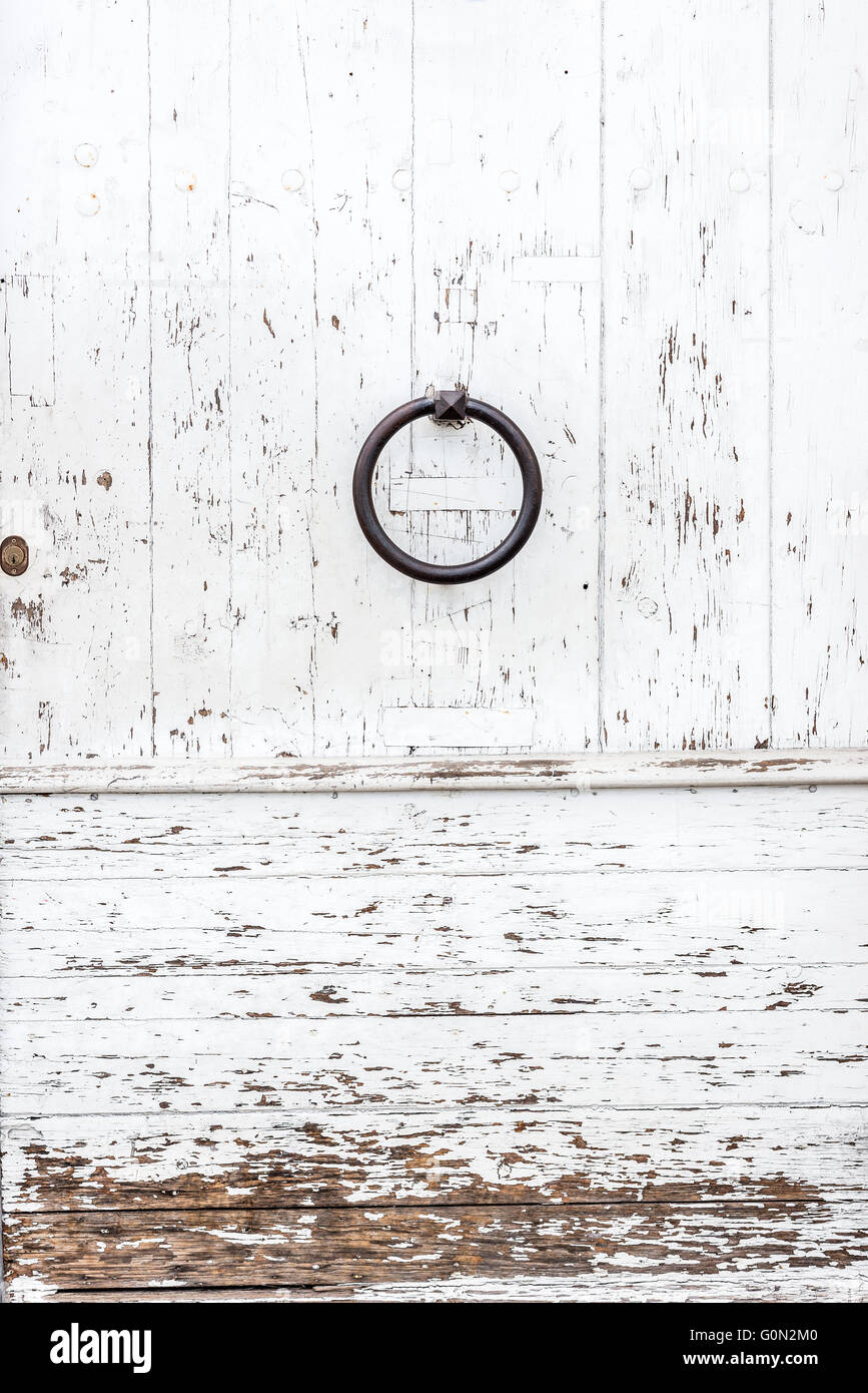Porte en bois blanc patiné avec un anneau en métal et bouton serrure  rouillée texturé avec peinture blanche écaillée et peeling Photo Stock -  Alamy