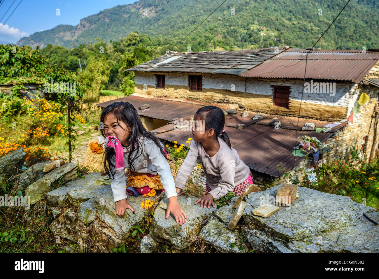 Deux jeunes filles népalaises jouent dans le jardin de leur maison Banque D'Images