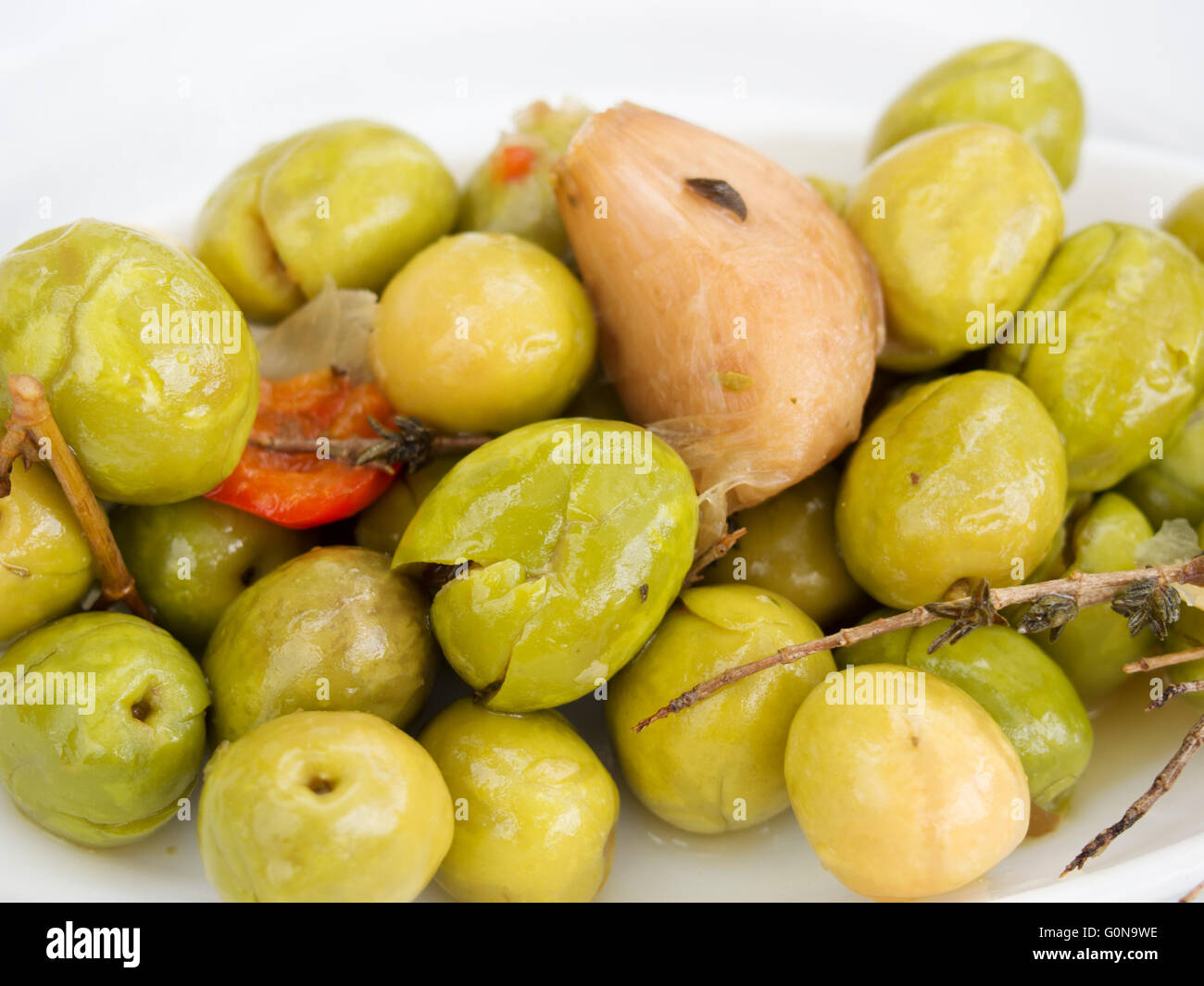 Olives vertes marinées avec des herbes et l'ail Banque D'Images